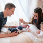 Baby liegt inmitten seiner Familie
